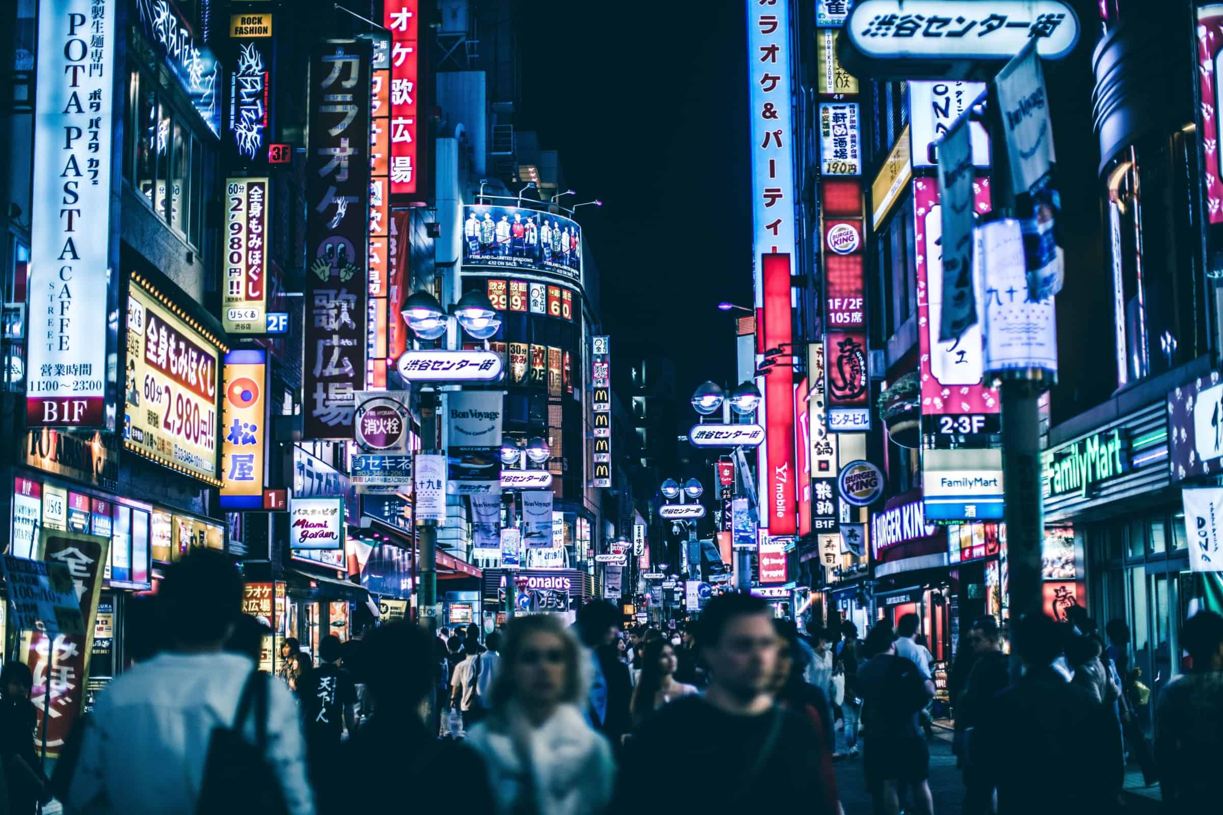 People walking down an asian street at night.